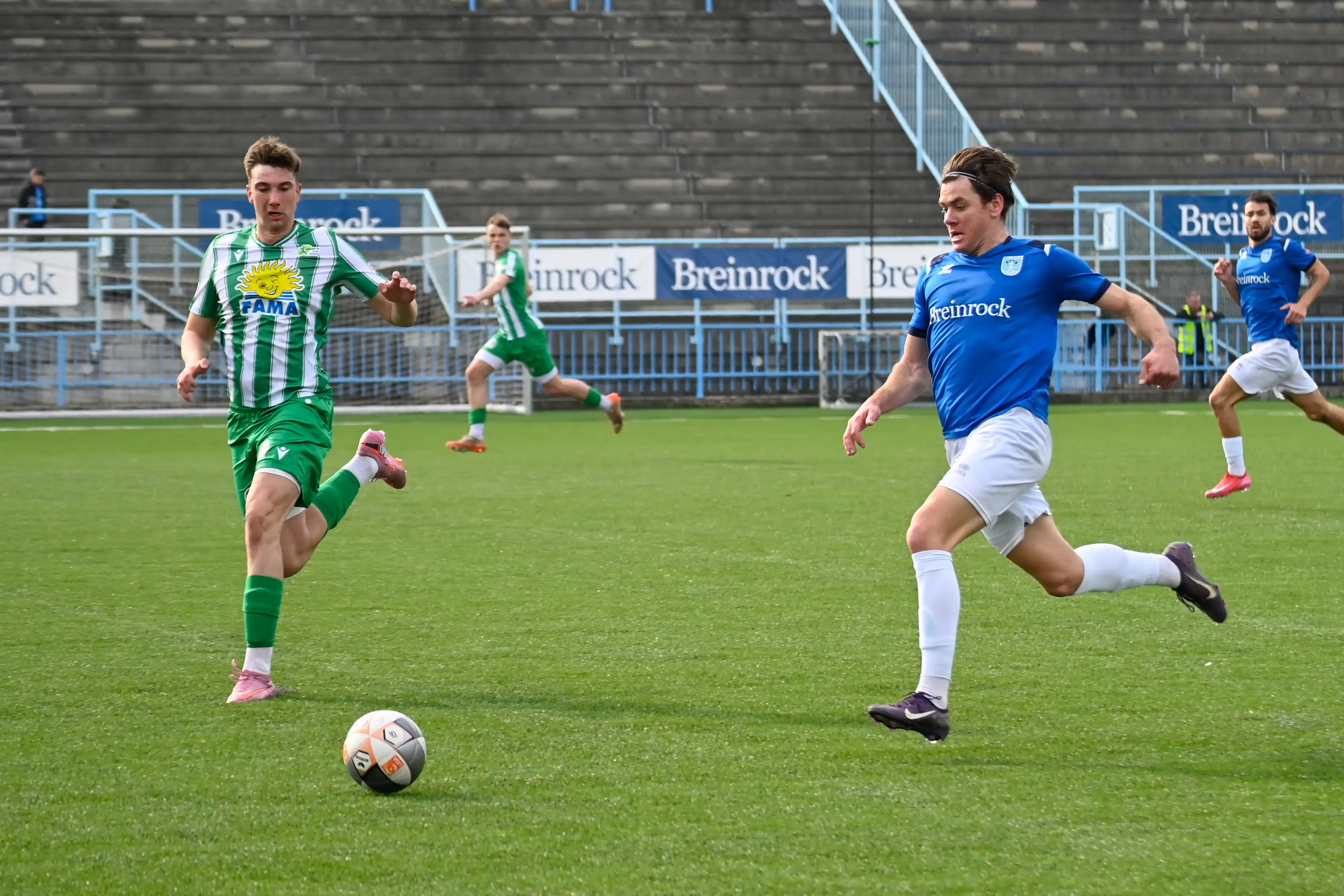 An NK Izola forward driving at a defender during a home match